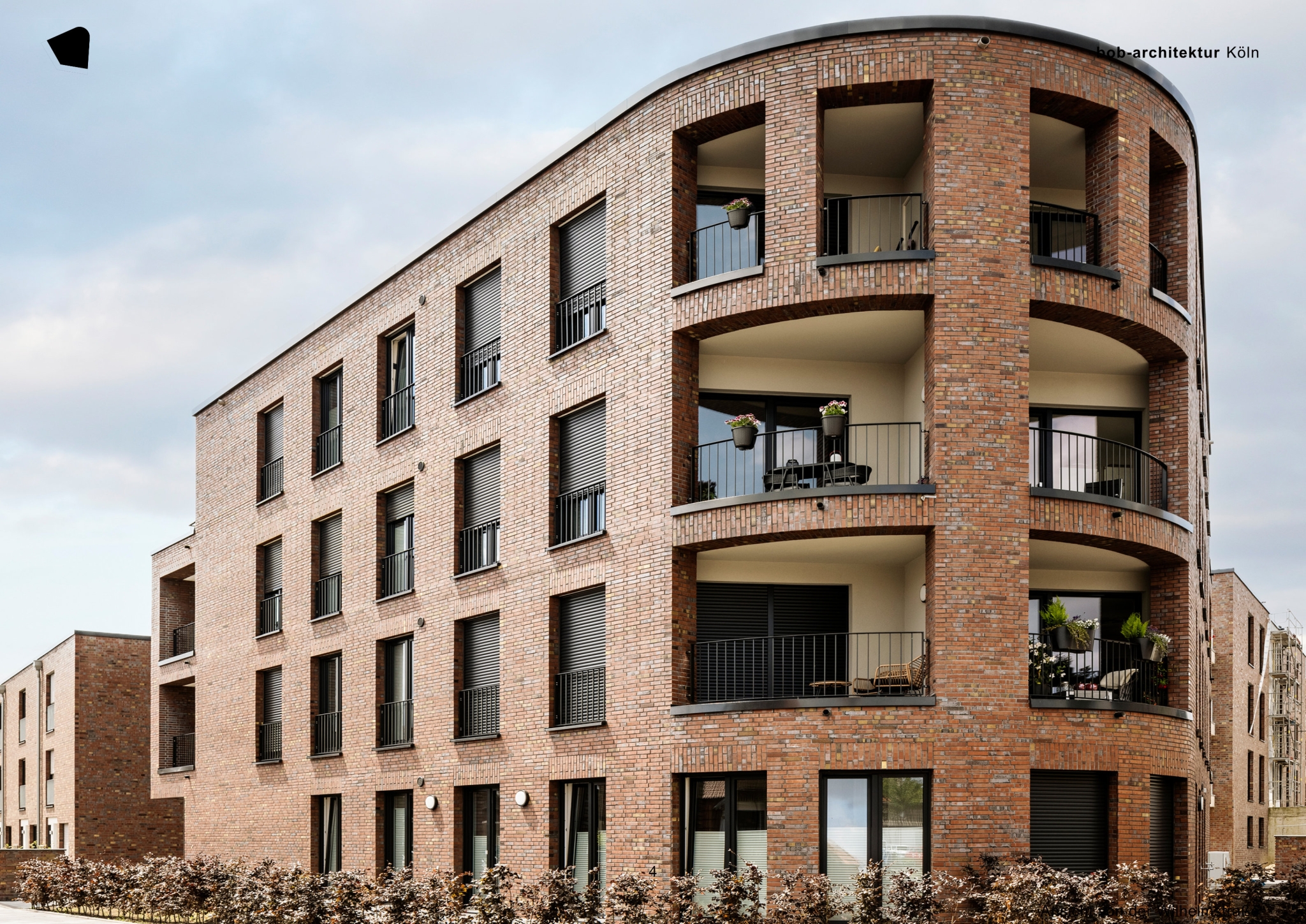 Mehrgeschossiges Wohngebäude mit abgerundeter Ecke und Backsteinfassade im Rathausquartier in Kamp-Lintfort mit einer besonderen Ziegelstruktur.